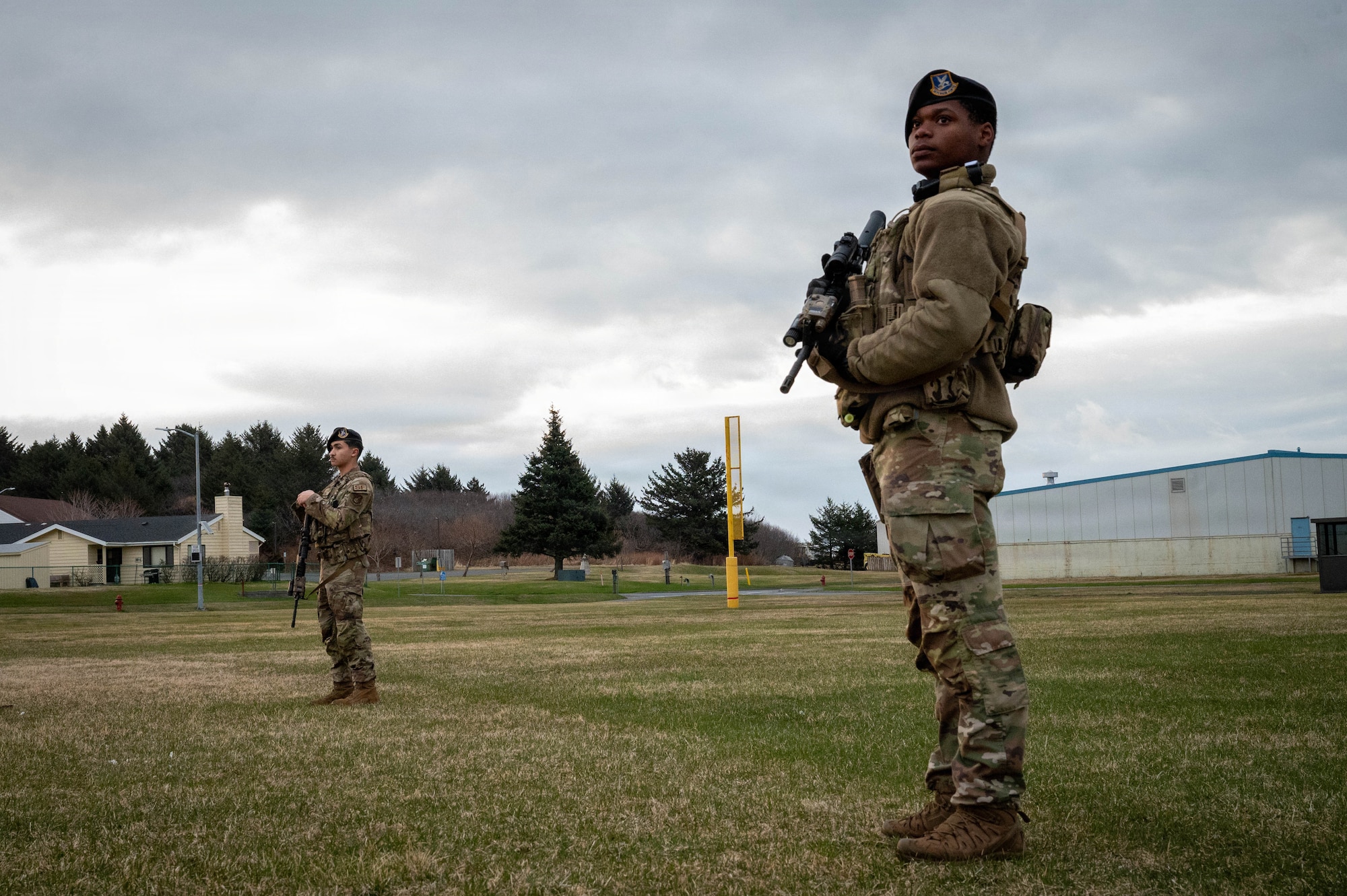 From the left, U.S. Air Force Airman Francesco Buffone and Airman 1st Class Jaden Hicks, 673d Security Forces defenders, stand guard at a spoke location during exercise Tropic Tundra 26 at Coast Guard Air Station Kodiak, Alaska, May 11, 2026.