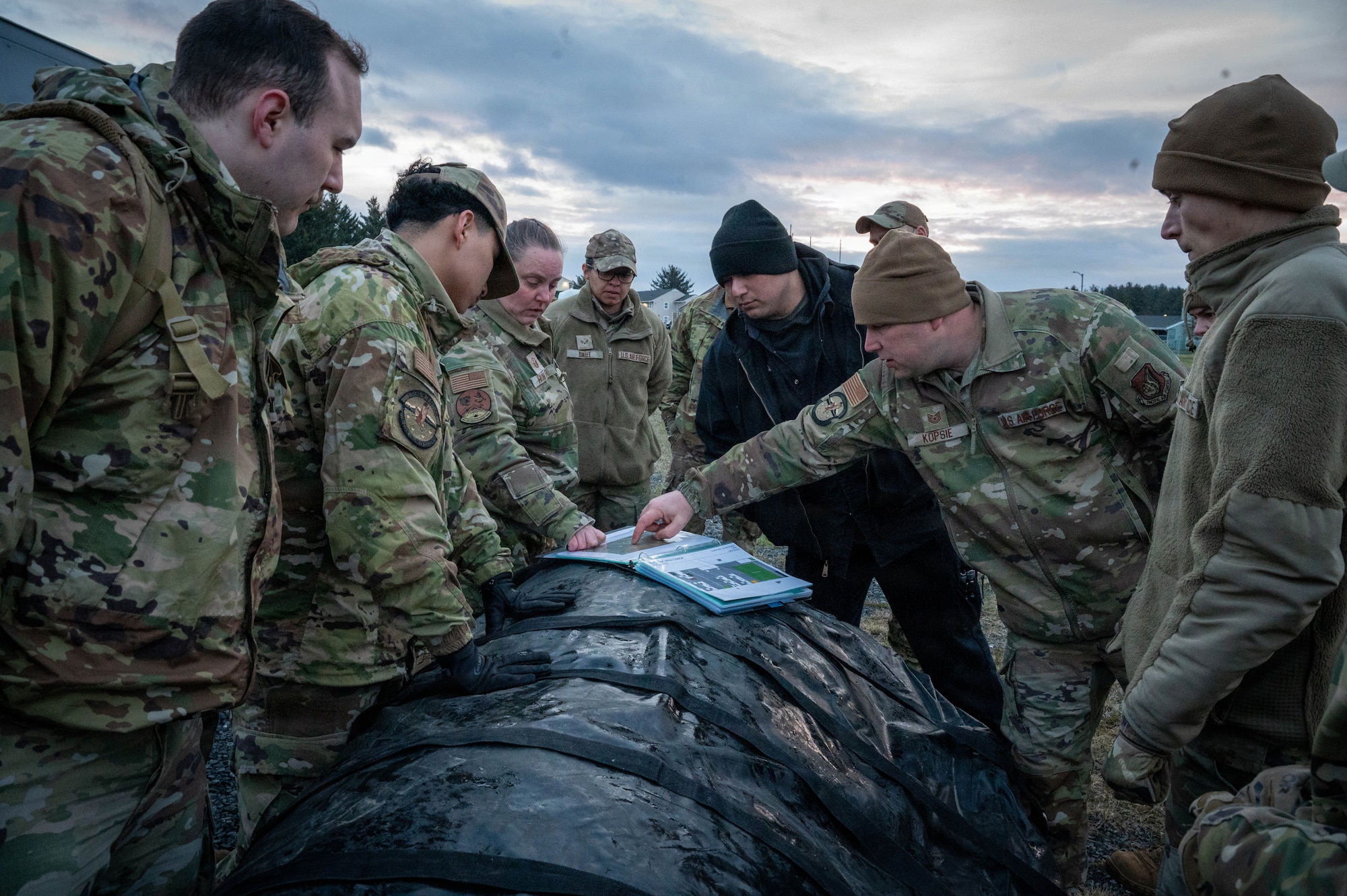 U.S. Airmen deployed with the 3rd Air Expeditionary Wing review a spoke setup plan during exercise Tropic Tundra 26 at Coast Guard Air Station Kodiak, Alaska, May 11, 2026.