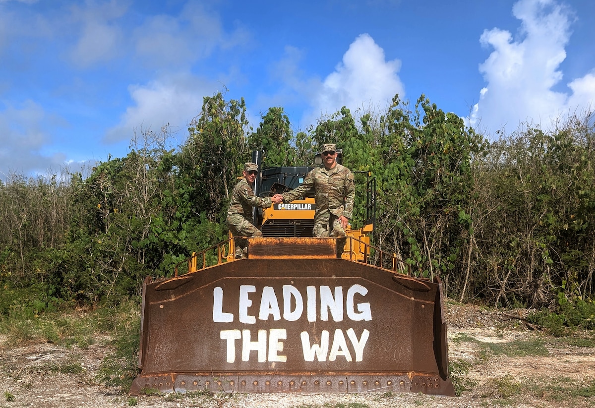 Two U.S. Air Force Airmen assigned to the 240th Civil Engineer Flight, Colorado Air National Guard pose on top of heavy machinery while deployed to the U.S. Indo-Pacific region during 2025. The 240 CEF completed a six-month deployment throughout various locations in the region, where they planned and rehabilitated key infrastructure. (courtesy photo)