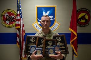 Airman poses with trophies
