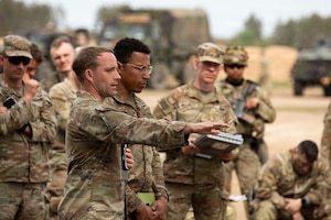 U.S. Army Capt. Harold McMurrin, commander, left, “Demon” Battery, Field Artillery Squadron, 2nd Cavalry Regiment, speaks of unmanned aerial systems movements alongside 1st Lt. Imoni Coss, deputy regimental signal operations officer, Regimental Higher Headquarters Troop, 2nd Cavalry Regiment, right, during the Combined Arms Rehearsal part of the Saber Strike exercise on May 5, 2026 at Bemowo Piskie Training Area, Poland. From April 27 to May 31, 2026 U.S. and Allied forces will exercise NATO’s Eastern Flank Deterrence Initiative, demonstrating NATO’s ability to fight and win on the modern battlefield. Nearly 15,000 troops from eleven nations will train across the High North, Baltic region, and Poland, executing rapid maneuvers, air defense, counter-drone operations, and cyber defense to validate NATO’s regional defense plans in real time. This series of linked exercises, including Saber Strike, Immediate Response, and Swift Response, turns investment into capability. Soldiers integrate unmanned systems, AI-enabled command and control, and live data networks to move faster, decide faster, and fight more effectively across all domains. Sword 26 demonstrates how U.S. Army Europe and Africa drives transformation at scale while strengthening deterrence. Together with our Allies, we are building a unified, lethal force ready to defend NATO territory and respond to any threat. (U.S. Army Reserve photo by Staff Sgt. Emilie Lenglain)