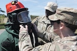 U.S. Soldiers aid Sgt. Josiah McBride, left, serving as part of the Massachusetts National Guard Chemical, Biological, Radiological and Nuclear, or CBRN, Task Force Search and Extraction Recon Team 1 in donning personal protective equipment during a CBRN Task Force collective training exercise at Camp Edwards Training Site, Joint Base Cape Cod, Massachusetts, May 16, 2026. Photo by Staff Sgt. Justin Leva.