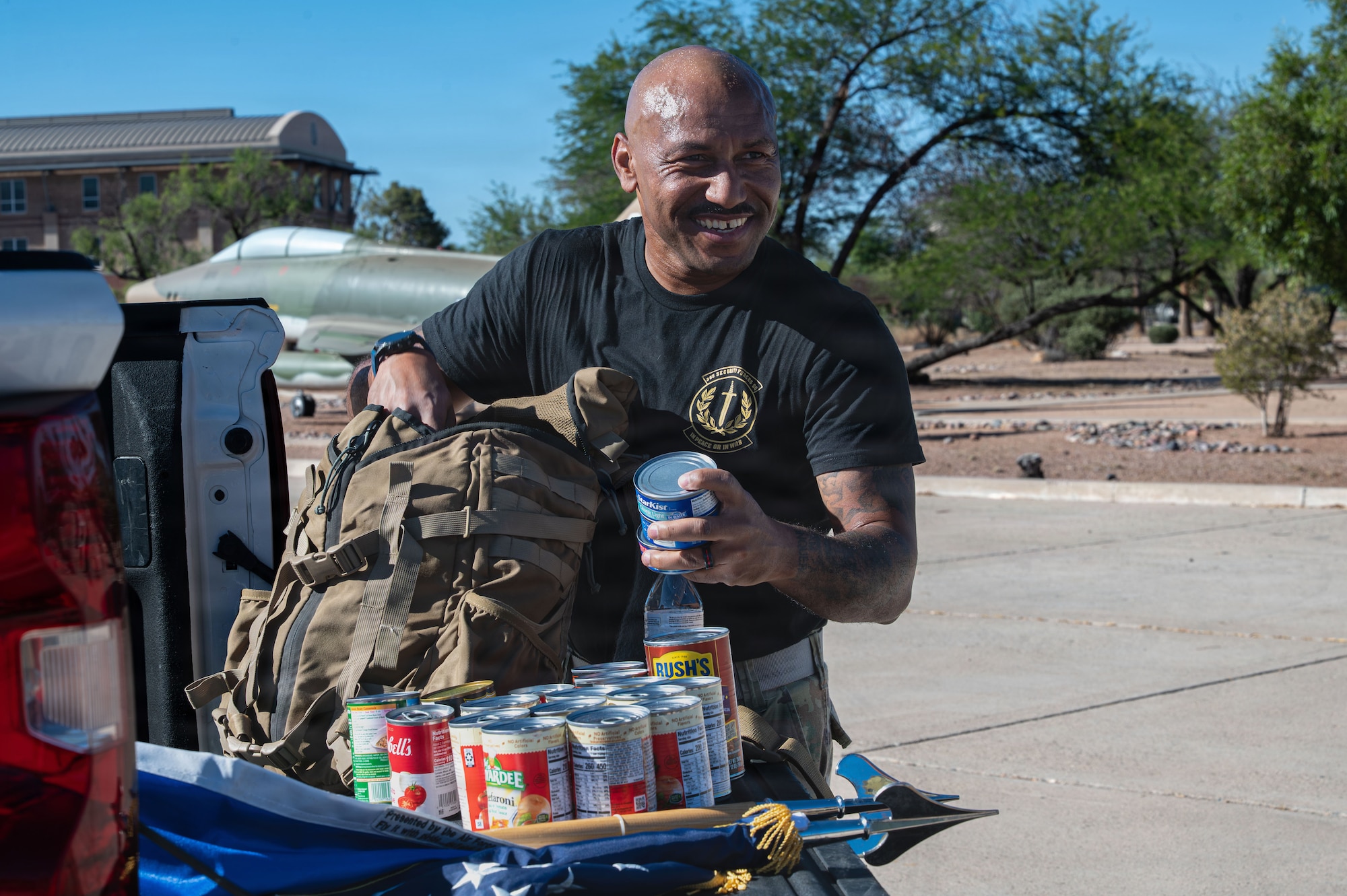 U.S. Air Force Chief Master Sgt. Kelvin Hatcher, 355th Wing command chief, unloads cans from a rucksack after the Police Week ruck at Davis-Monthan Air Force Base, Arizona, May 18, 2026. The commitment to serve others through sacrifice, including efforts like a can drive, demonstrates resilience in every fight. (U.S. Air Force photo by Airman 1st Class Rachael Wright)
