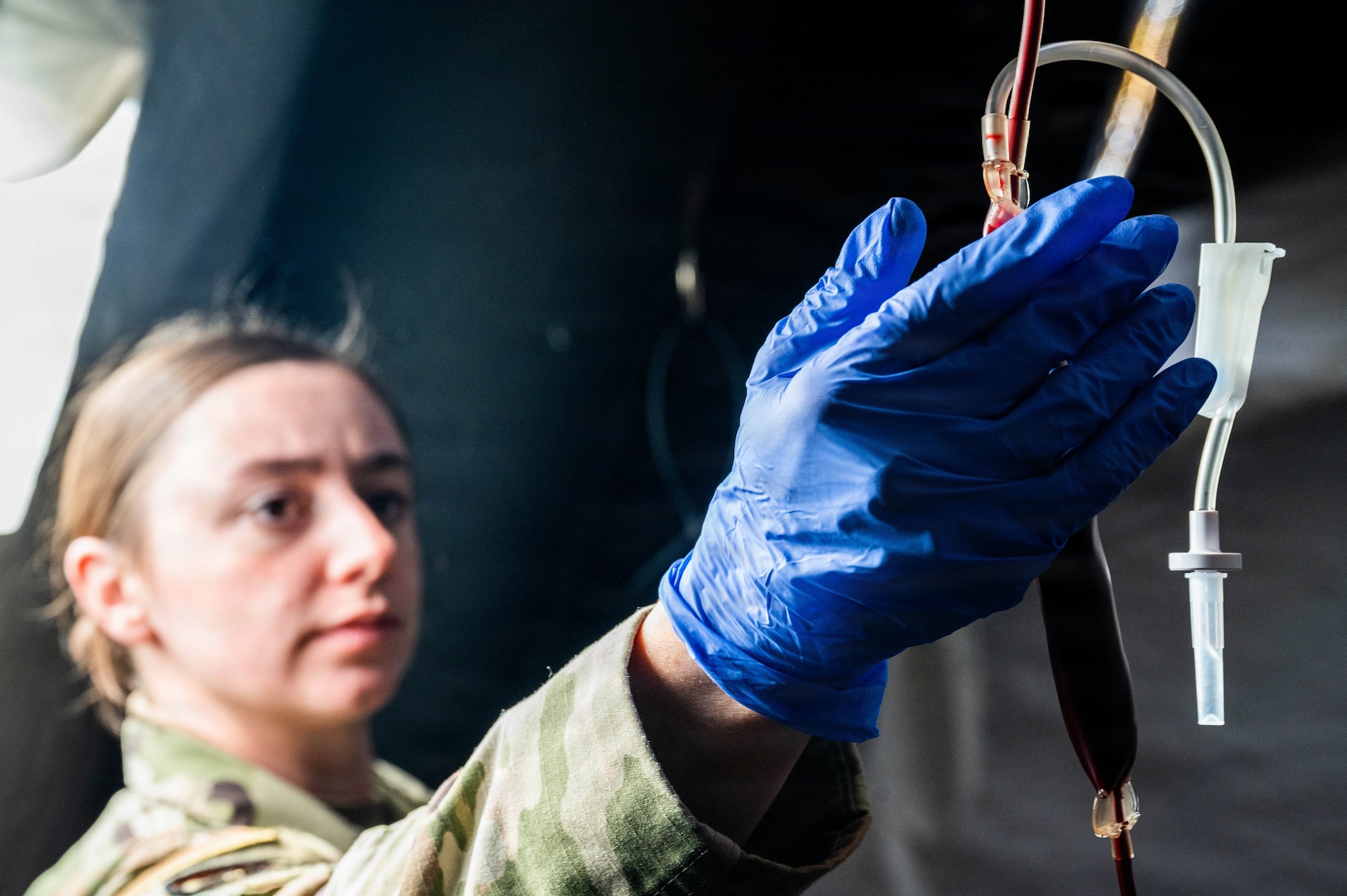 U.S. Air Force Senior Airman Storrm Yaggie, 525th Fighter Squadron independent duty medical technician, ensures the flow of blood in an emergency blood transfusion scenario during exercise Tropic Tundra 26 at Coast Guard Air Station Kodiak, Alaska, May 14, 2026.