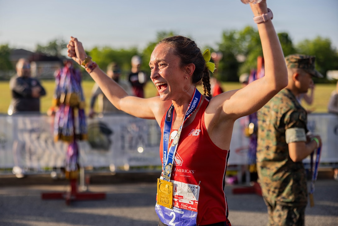 Natalie Daniels, the female first-place runner, celebrates after crossing the finish line during the 2026 Marine Corps Historic Half in Fredericksburg, Virginia, May 17, 2026. The Historic Half is a 13.1-mile race weaved throughout Historic Downtown Fredericksburg, home to over 200 businesses and several historic sites. The annual race generates community goodwill, fosters public relations, and increases advocacy for individual health while emphasizing the Marine Corps’ warrior ethos. (U.S. Marine Corps photo by Sgt. Dean Gurule)