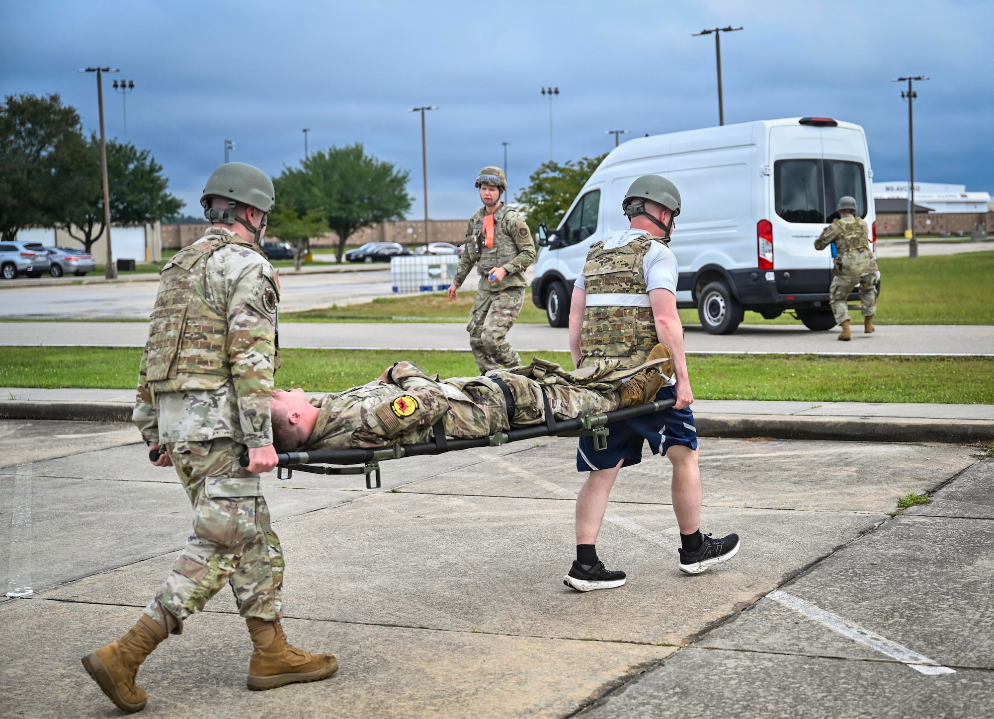 military members carry a man on a stretcher.