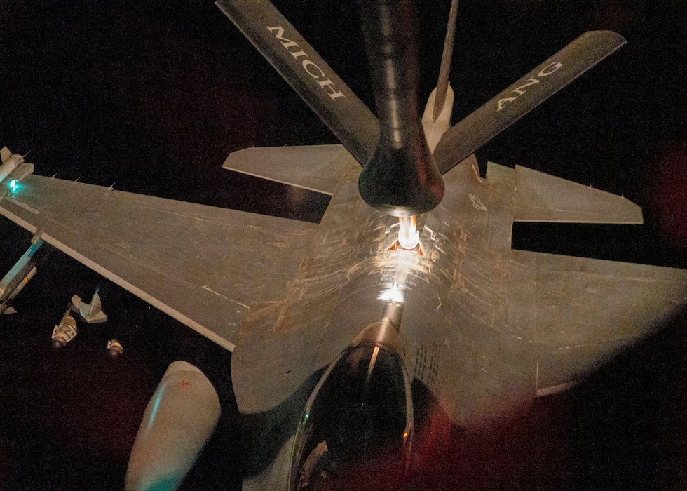 Aerial refueling in night conditions over populated, well lit area.