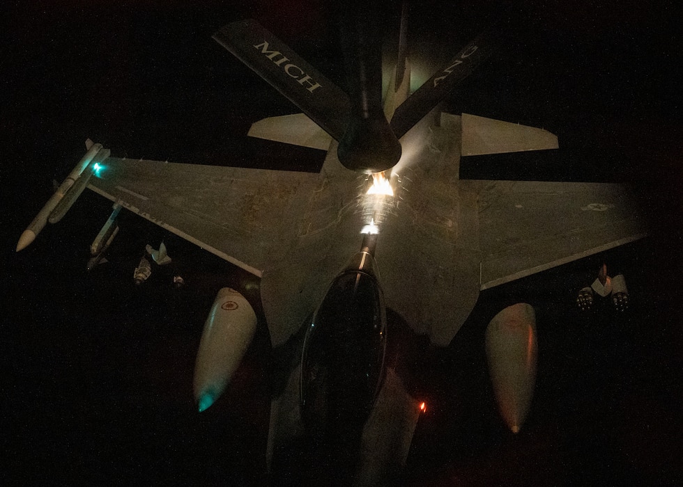 Aerial refueling in night conditions over populated, well lit area.