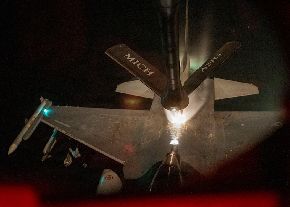 Aerial refueling in night conditions over populated, well lit area.