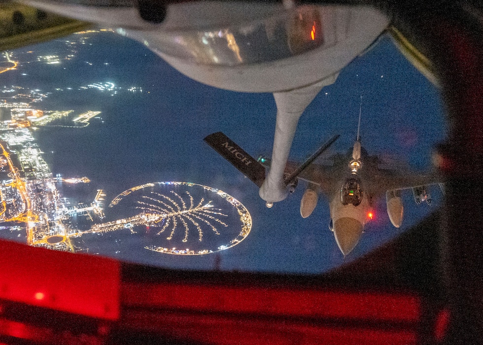 Aerial refueling in night conditions over populated, well lit area.
