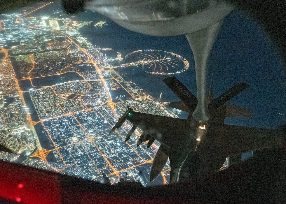 Aerial refueling in night conditions over populated, well lit area.