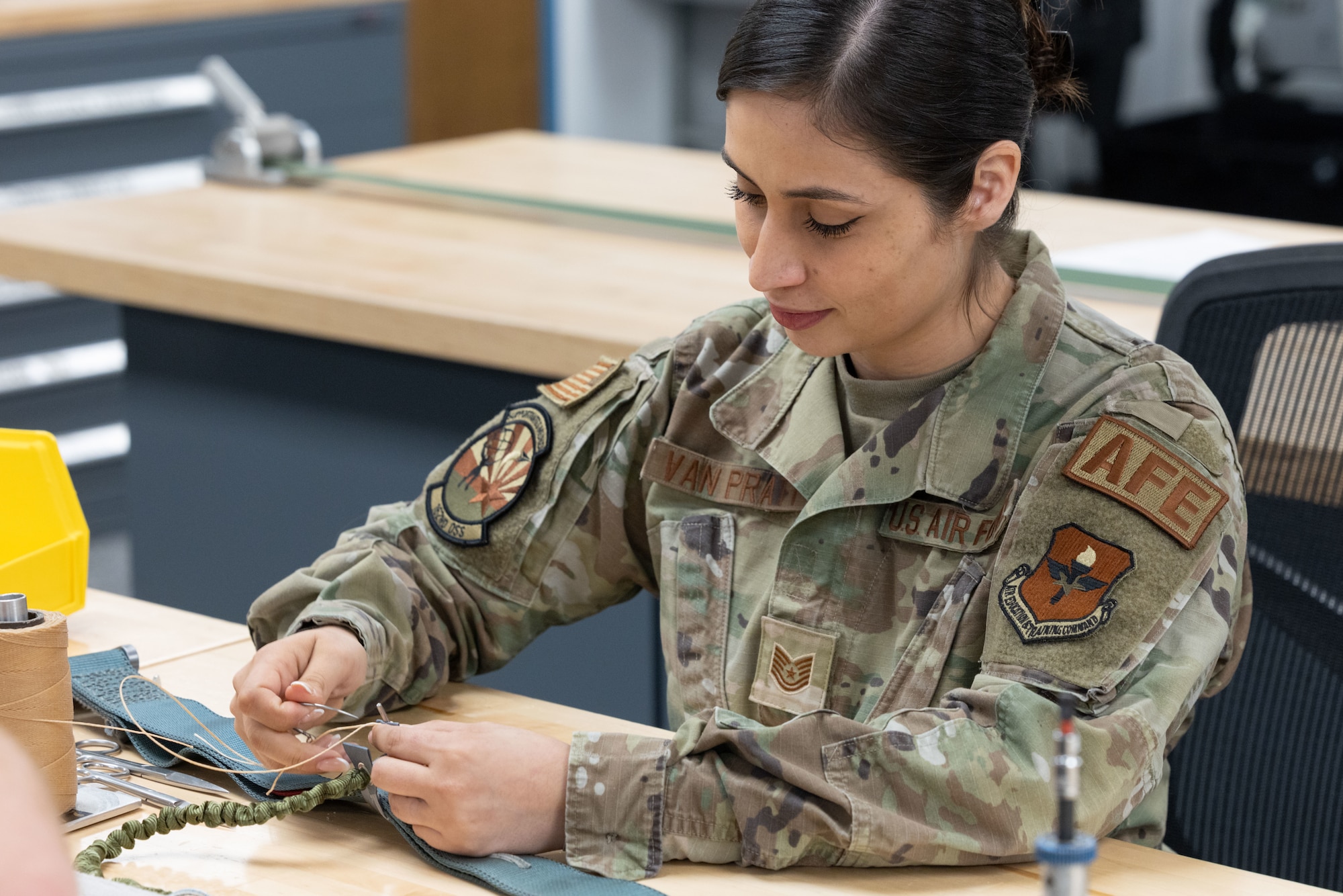 U.S. Air National Guard Tech. Sgt. Fernanda Van Pratt, 162nd Aircrew Flight Equipment noncommissioned officer in charge, stitches a parachute at Morris Air National Guard Base, Ariz., May 1, 2026. During a major vertical inspection the 162nd AFE flight earned a top-tier rating, leading the inspector to share their modernized mobility deployment kits with Air National Guard units nationwide, enhancing mission adaptability across the force. (U.S. Air National Guard photo by Tech. Sgt. Hampton Stramler)