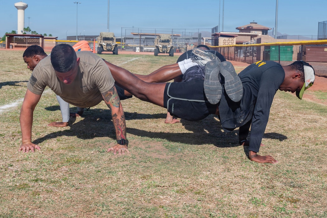 U.S. Air Force Senior Airman Joseph Kuka, front left, and Staff Sgt. Jacoby West, both 56th Security Forces Squadron entry controllers, perform square pushups as part of the defenders challenge held during 2026 Police Week at Luke Air Force Base, Arizona, May 11, 2026. The event provided a moment of observance for law enforcement officers and their sacrifice to the partnerships and communities they serve. (U.S. Air Force photo by Airman 1st Class Tekorey Watkins)