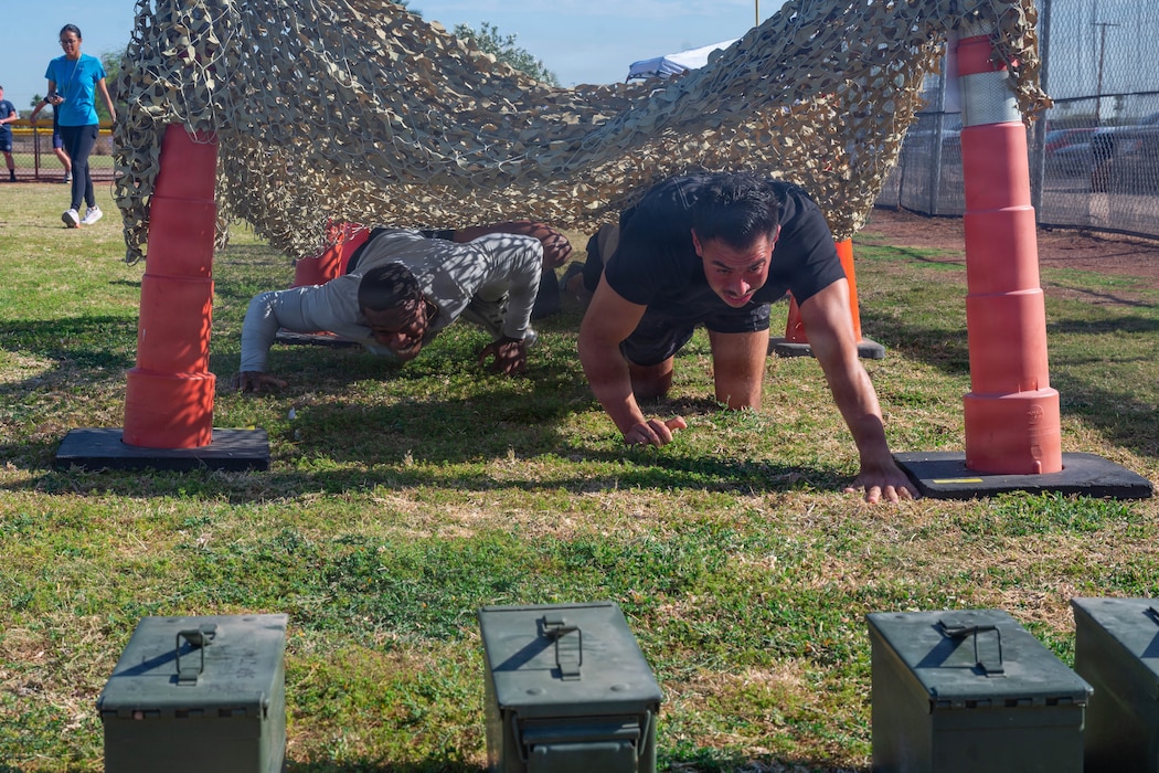 U.S. Air Force Airman 1st Class Wiliam Finnie, 56th Security Forces Squadron armorer, left, and Staff Sgt. Christopher Haaland, 56th SFS law enforcement patrolman, crawl through an obstacle course as part of the defenders challenge held during 2026 Police Week at Luke Air Force Base, Arizona, May 11, 2026. Airmen demonstrated a warrior ethos during the defender challenge, honoring law enforcement officers in support of the nation’s defense posture and projection of the global strategic mission. (U.S. Air Force photo by Airman 1st Class Tekorey Watkins)