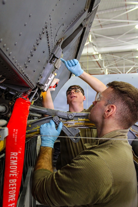 Two airmen working on a jet