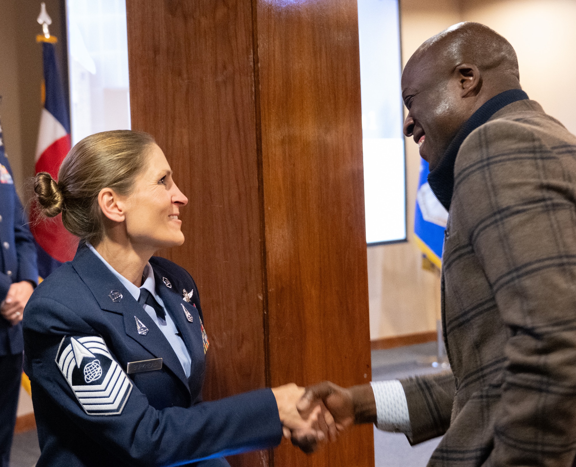 Chief Master Sgt. Burkhead shakes Mayor Mobolade's hand at the event.