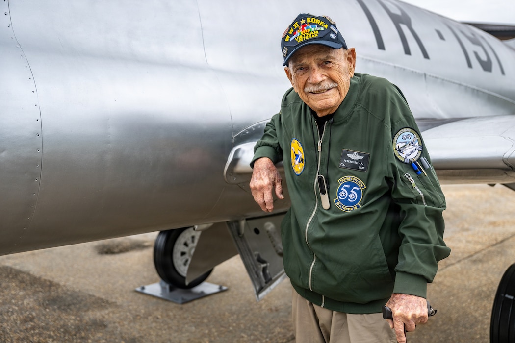 Retired Colonel standing outside of an airplane.
