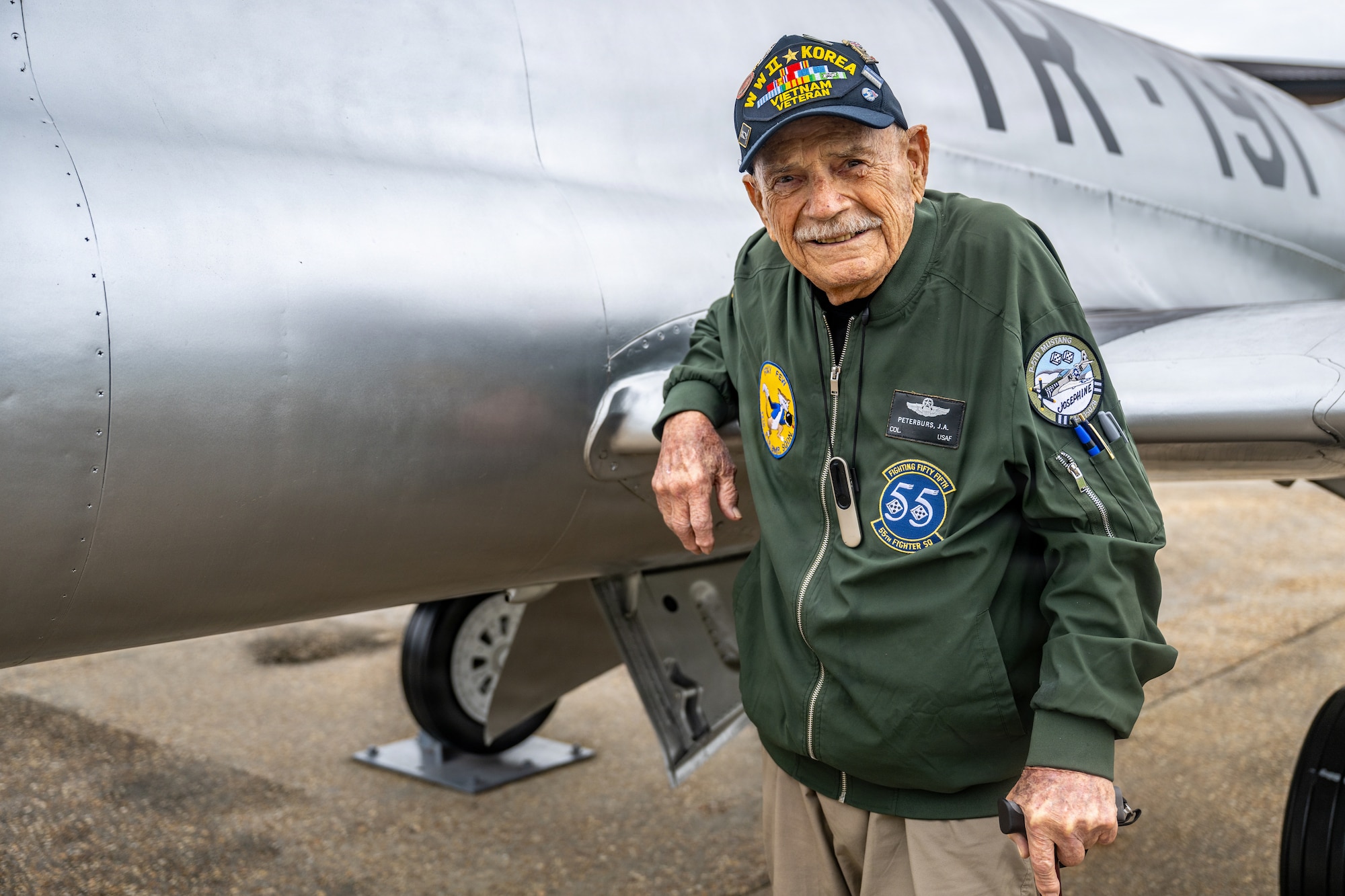 Retired Colonel standing outside of an airplane.
