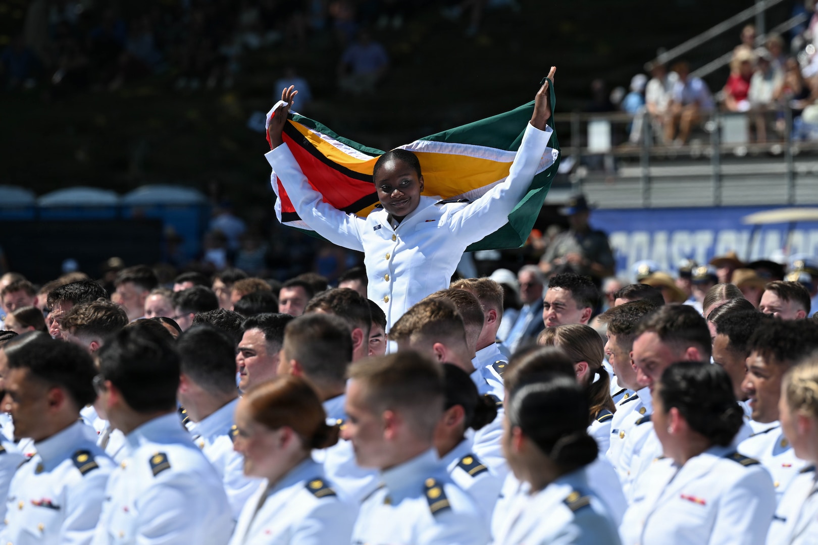 U.S. Coast Guard Academy international cadet Virlyn Gibson, from Guyana, holds her country’s flag during the academy’s graduation ceremony in New London, Connecticut, May 20, 2026. The Class of 2026 included international students who will return to serve in their respective countries following graduation. (U.S. Coast Guard photo by Petty Officer 3rd Class Lyric Jackson)