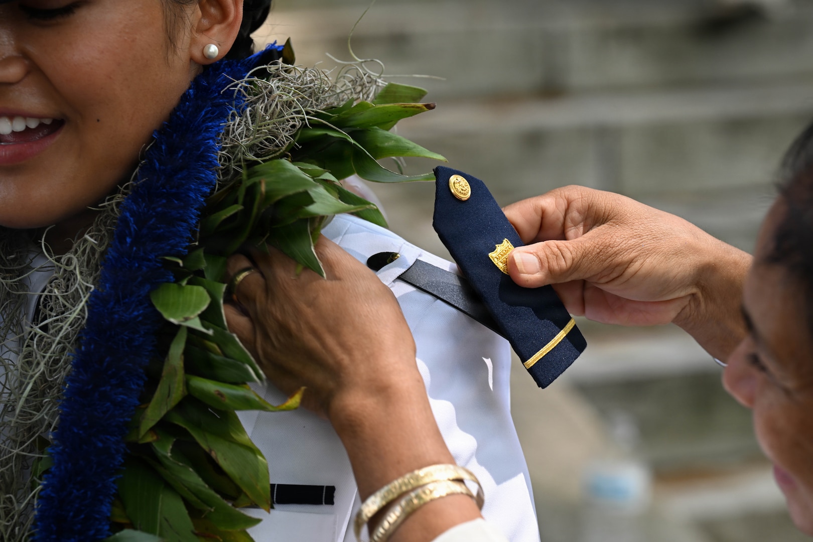 Ensign Tealani Wasson has her shoulder boards replaced by a family member following the U.S. Coast Guard Academy graduation ceremony in New London, Connecticut, May 20, 2026. The placement of ensign shoulder boards marks a graduate’s transition into the officer corps.