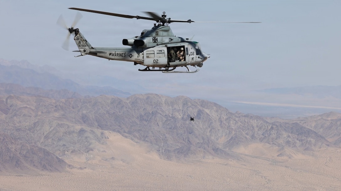 Marines aboard a UH-1Y Venom assigned to Marine Light Attack Helicopter Squadron (HMLA) 169, Marine Aircraft Group 39, 3rd Marine Aircraft Wing, toss a first person view unmanned aircraft system during an integration assessment exercise at Marine Corps Air Ground Combat Center, Twentynine Palms, California, May 13, 2026.