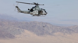 Marines aboard a UH-1Y Venom assigned to Marine Light Attack Helicopter Squadron (HMLA) 169, Marine Aircraft Group 39, 3rd Marine Aircraft Wing, toss a first person view unmanned aircraft system during an integration assessment exercise at Marine Corps Air Ground Combat Center, Twentynine Palms, California, May 13, 2026.