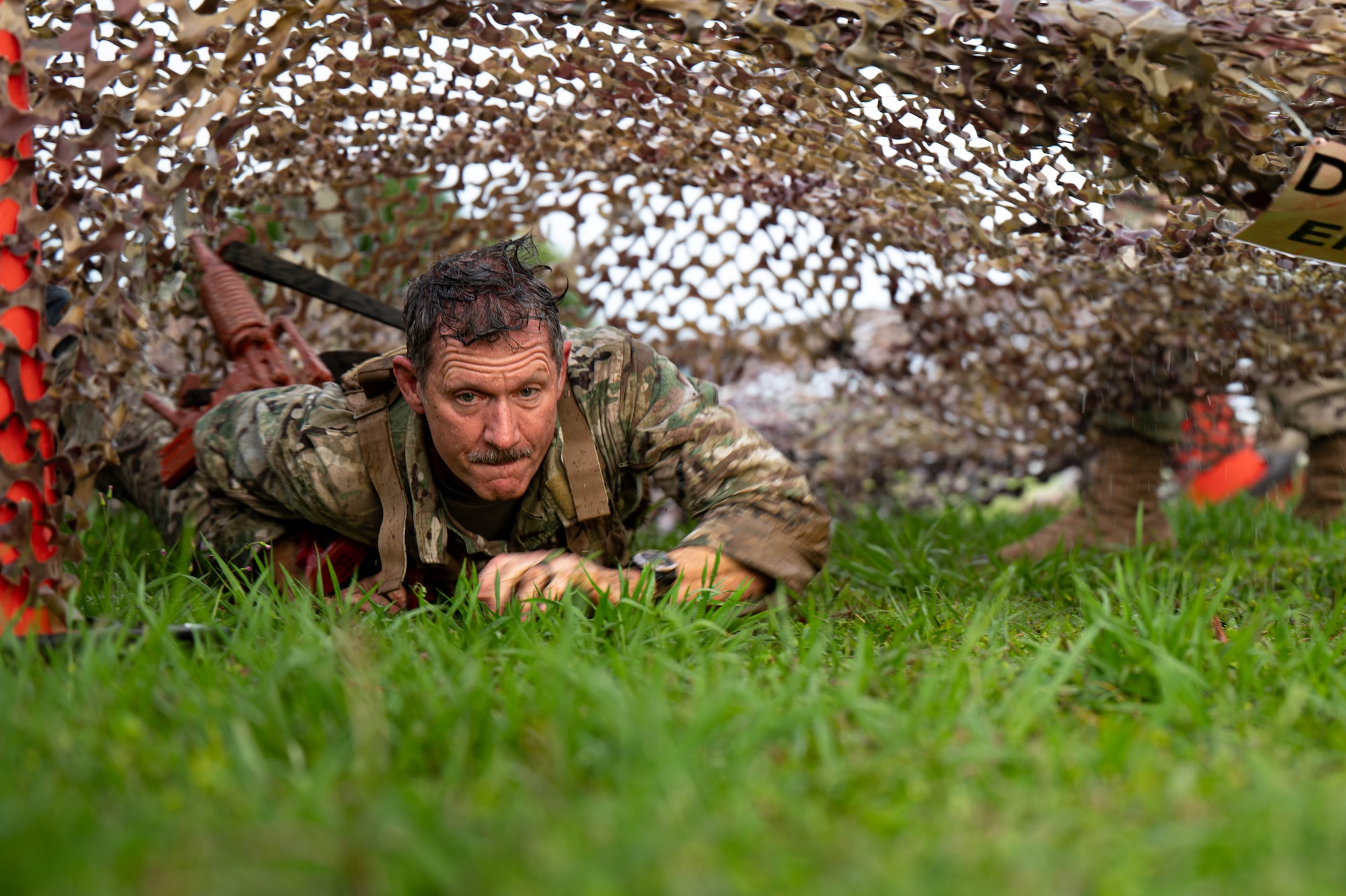 U.S. Air Force Brig. Gen. John Gallemore, 18th Wing commander, crawls under an obstacle while participating in the Combat Readiness Challenge at Kadena Air Base, Japan, May 15, 2026. The challenge tested participants through a series of physically demanding obstacles designed to reinforce combat readiness, resilience and mission-focused teamwork. (U.S. Air Force photo by Airman 1st Class Nathaniel Jackson)