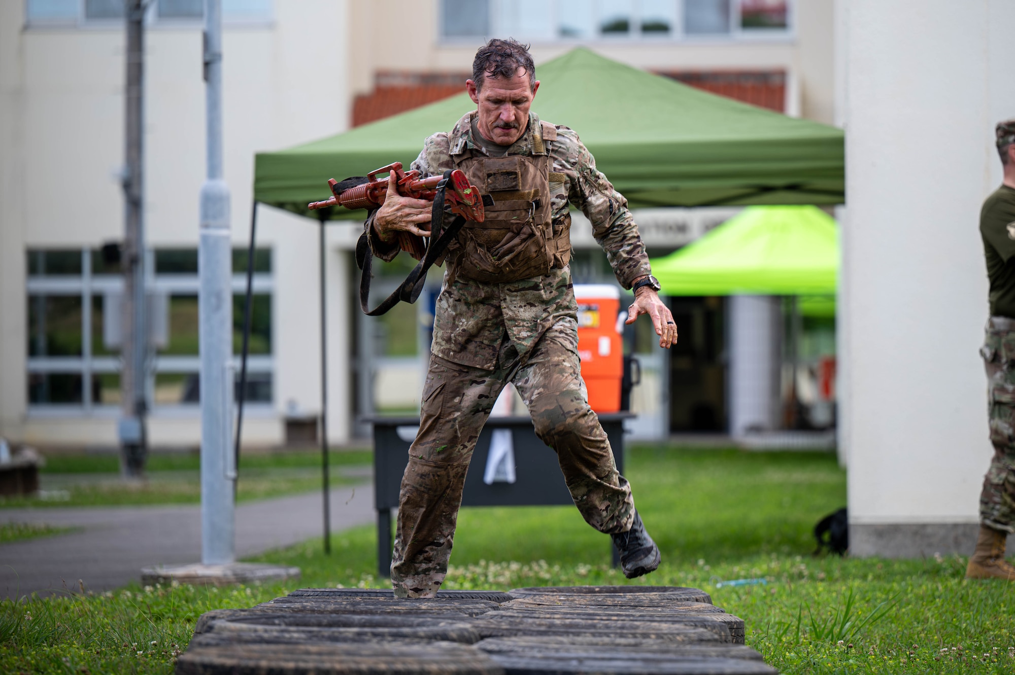 U.S. Air Force Brig. Gen. John Gallemore, 18th Wing commander, jumps through tires while participating in the Combat Readiness Challenge at Kadena Air Base, Japan, May 15, 2026. The challenge tested participants through a series of physically demanding obstacles designed to reinforce combat readiness, resilience and mission-focused teamwork. (U.S. Air Force photo by Airman 1st Class Nathaniel Jackson)