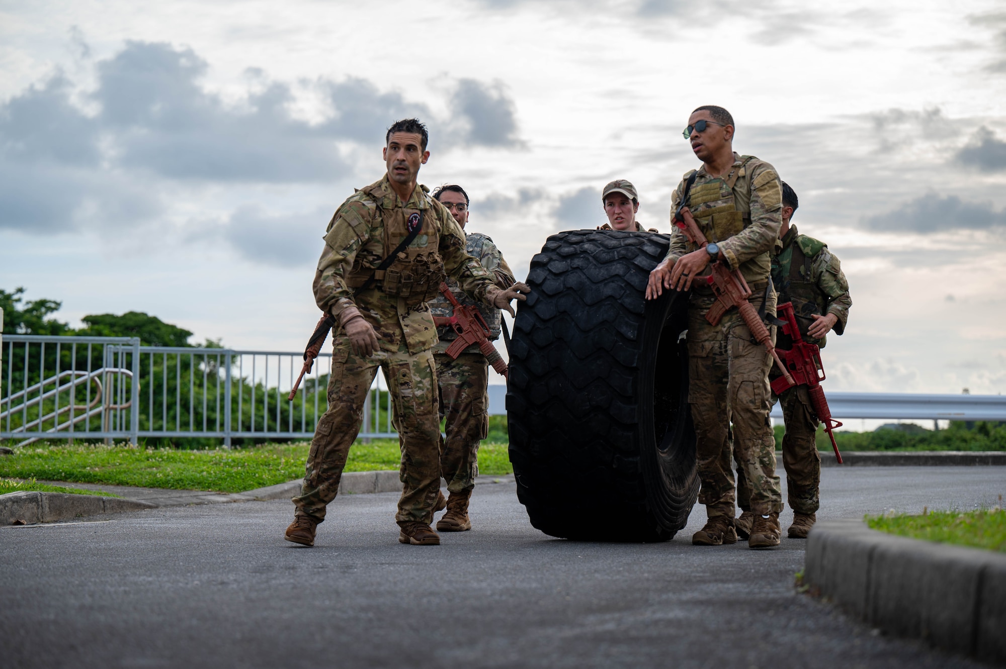 U.S. Air Force Col. Robert Arnett, left, 18th Wing deputy commander, and the 18th Wing command team roll a tire while participating in the Combat Readiness Challenge at Kadena Air Base, Japan, May 15, 2026. The challenge highlighted the importance of physical fitness and mental toughness in maintaining mission readiness across the Indo-Pacific. (U.S. Air Force photo by Airman 1st Class Nathaniel Jackson)