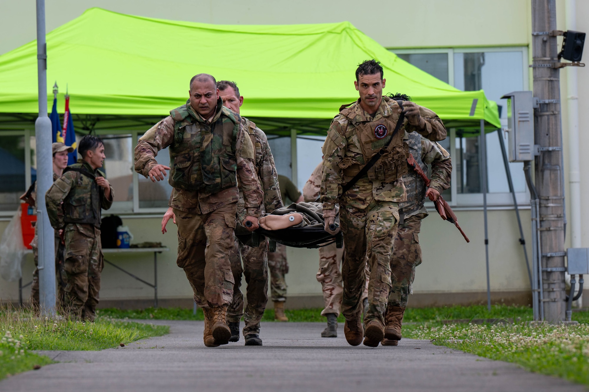 The U.S. Air Force 18th Wing command team carries a simulated casualty while participating in the Combat Readiness Challenge at Kadena Air Base, Japan, May 15, 2026. The event served as an opportunity for leadership to engage directly with Airmen while promoting a culture centered on resilience and warrior ethos. (U.S. Air Force photo by Airman 1st Class Nathaniel Jackson)