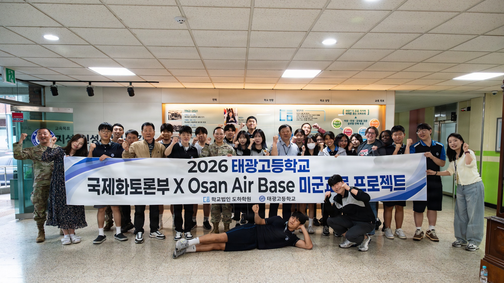 A group of people pose for a photo holding a banner.