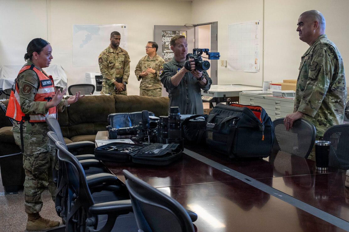 U.S. Air Force Airman 1st Class Jessel Fabara, left, 35th Fighter Wing (FW) Public Affairs (PA) specialist, briefs Col. Paul Davidson, 35th FW commander, and Chief Master Sgt. David Najera, right, 35th FW command chief, about her roles in the PA mission during a Wild Weasel Walk-through at Misawa Air Base, Japan, May 18, 2026. (U.S. Air Force photo by Senior Airman Gavin Hameed)