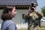 U.S. Air Force Chief Master Sgt. David Najera, 35th Fighter Wing (FW) command chief, takes a photograph of Airman 1st Class Hannah Bench, 35th FW Public Affairs specialist during a Wild Weasel Walk-through of the 35th FW public affairs unit at Misawa Air Base, Japan, May 18, 2026. (U.S. Air Force photo by Senior Airman Gavin Hameed)