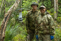 U.S. Navy Hospital Corpsman 2nd Class Alicia Hernandez, left, with 3rd Medical Battalion, 3rd Marine Logistics Group, and U.S. Air Force Airman 1st Class Emerald Domaoal, a pest management technician with the 18th Civil Engineer Squadron, 18th Wing, pose for a photo after setting up a Center of Disease Control mini light trap during a joint preventive medicine training at Jungle Warfare Training Center, Camp Gonsalves, Okinawa, Japan, May 5, 2026. The training enhances proficiency in preventive medicine techniques such as pest management, insect identification, sanitation, water testing, and disease mitigation improving participants’ exposure to the tools and responsibilities tied to their MOS, while reinforcing their role in protecting the warfighter. Hernandez is a native of Texas and Domaoal is a native of Guam. (U.S. Marine Corps photo by Cpl. Jonathan Rodriguez Pastrana)