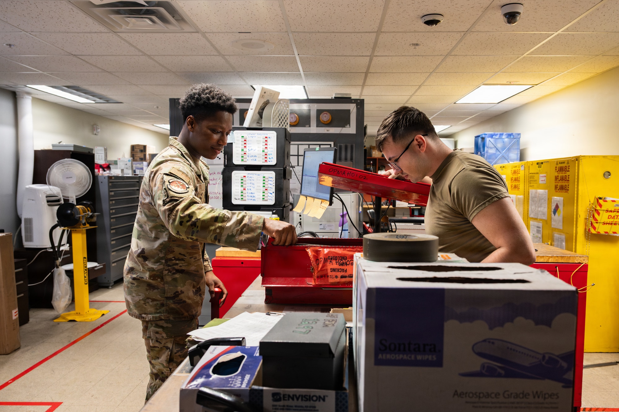 Two Airmen look at tools.