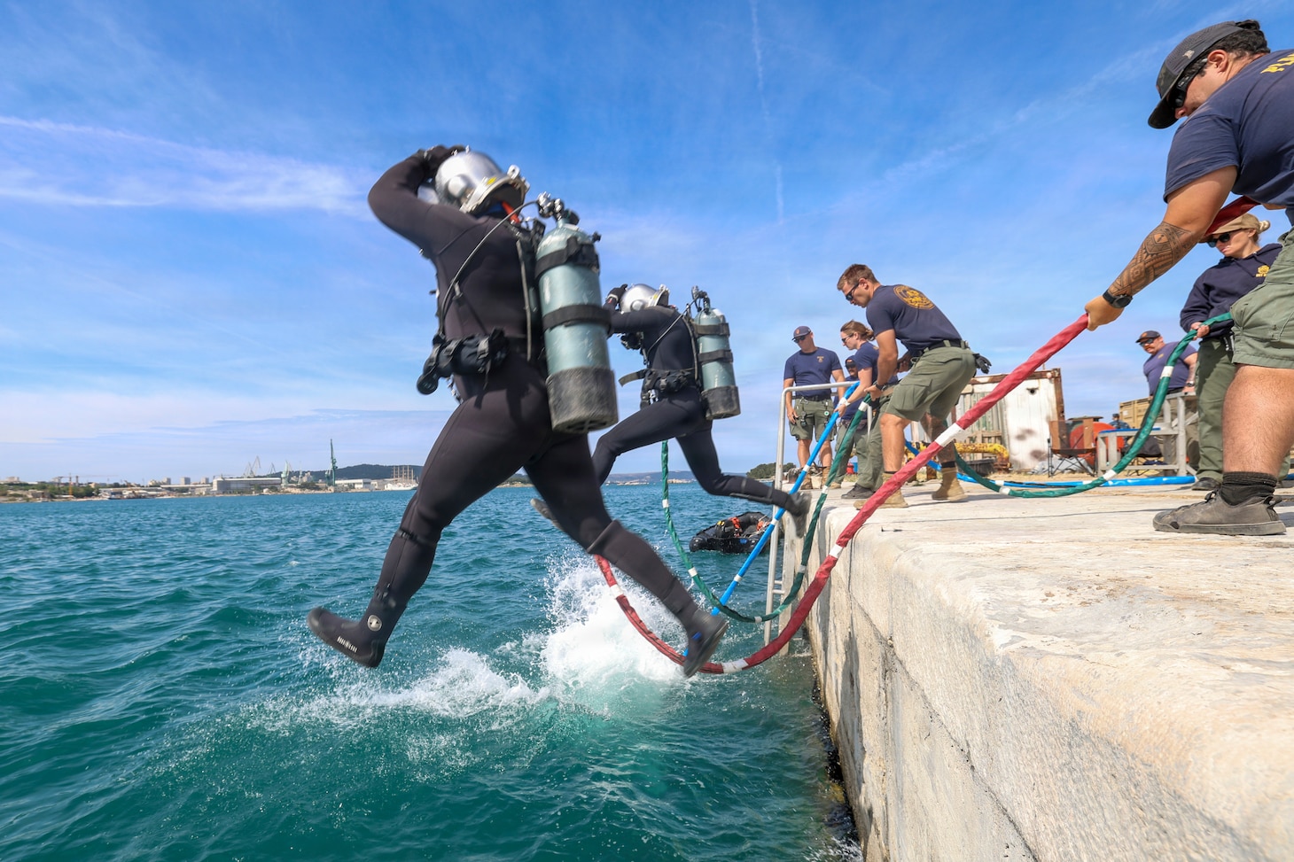 U.S. Navy Seabee divers assigned to Underwater Construction Team (UCT) 1, Construction Dive Detachment Charlie (CDD/C), front step into the water to conduct infrastructure repairs and assessments at the Port Brizine fuel terminal Split, Croatia, May 5, 2026.