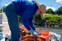 Jennifer McDonnell, 11th Civil Engineer Squadron environmental team chief, prepares to release a basket of mussels during a freshwater mussel deployment event at Joint Base Anacostia-Bolling, Washington, D.C., May 15, 2026. Freshwater mussels serve as natural biological filtration systems; a single mussel can filter gallons of water daily, removing algae, bacteria and particulates from the water column. (U.S. Air Force photo by Senior Airman Shanel Toussaint)