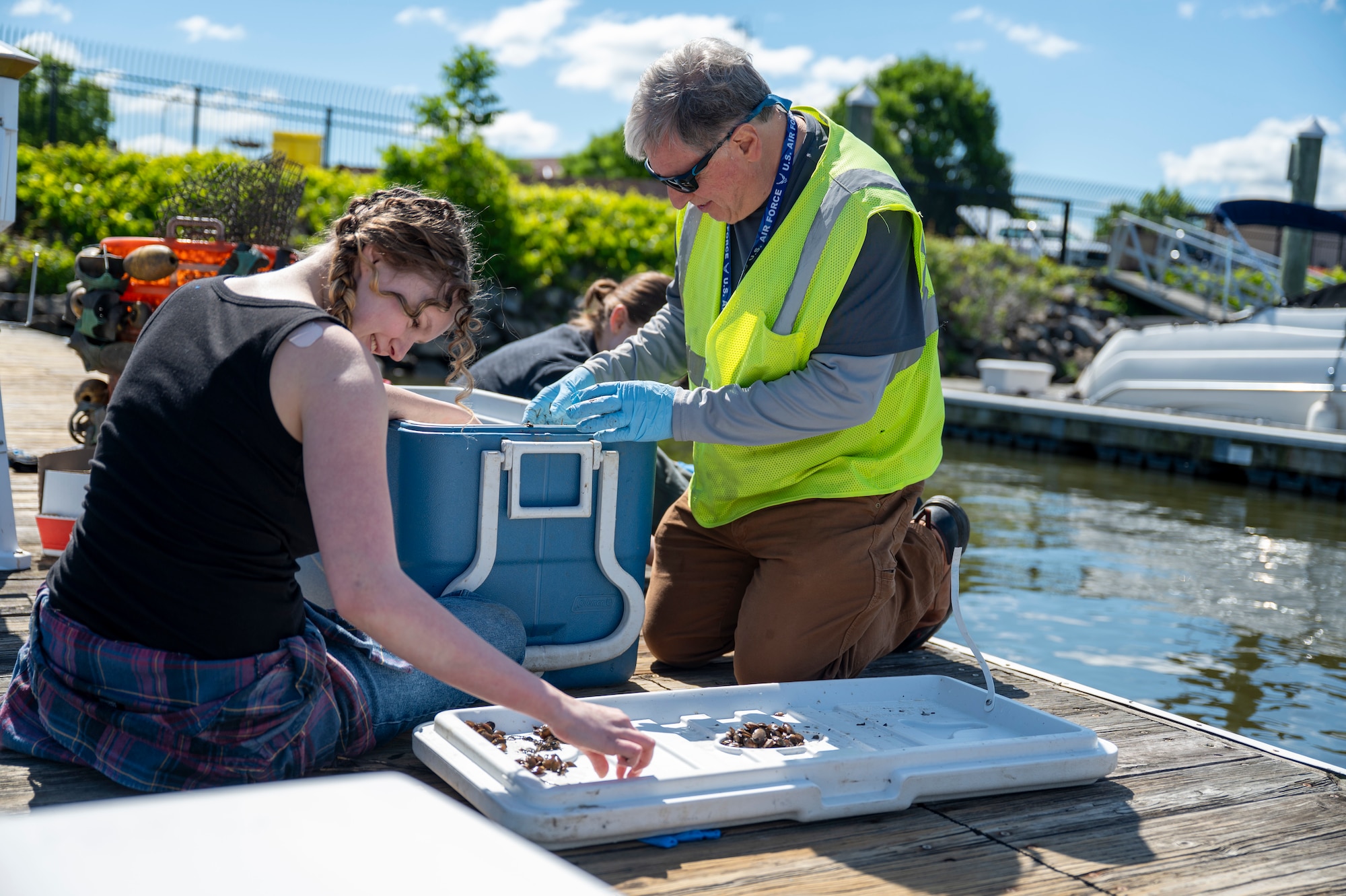 Emma Schuldt, a student volunteer assisting the 11th Civil Engineer Squadron, (left) and Michael Hooks, environmental team member, count mussels in preparation for freshwater mussel deployment event at Joint Base Anacostia-Bolling, Washington, D.C., May 15, 2026. These nurseries create a more resilient ecosystem, directly benefiting native wildlife and the overall health of the Potomac River by removing algae, bacteria, and particulates from the water column. (U.S. Air Force photo by Senior Airman Shanel Toussaint)