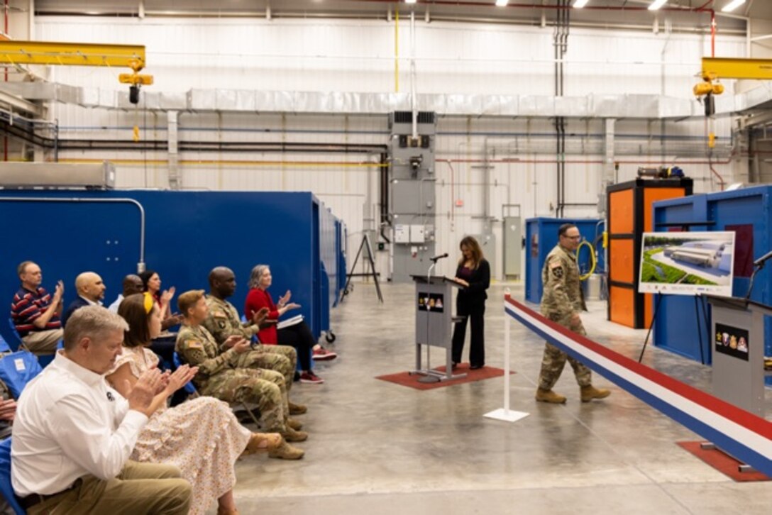 Picture of a woman speaking at a podium for a ribbon cutting.