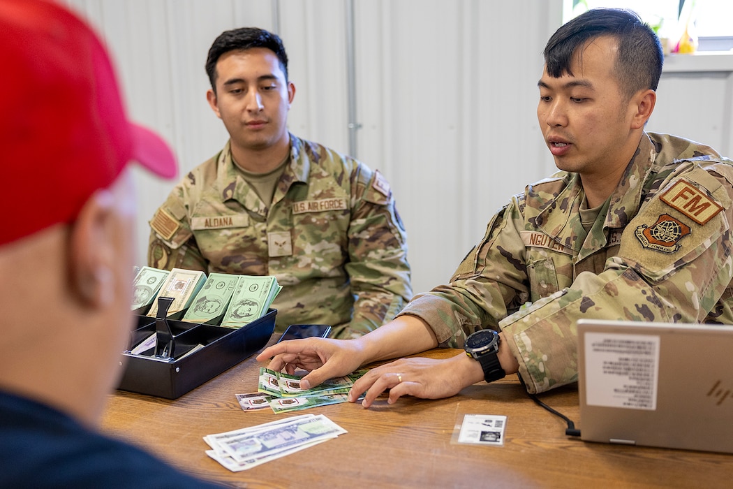 Photos shows uniformed individuals counting out fake money from a cash till.