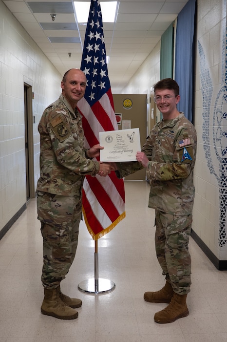 U.S. Air Force Lt. Col. Benjamin Shearer, 312th Training Squadron commander, presents a certificate of training to U.S. Space Force Sgt. Hayden Langfitt, 533rd Training Squadron Detachment 1 student, inside the Louis F. Garland Department of War Fire Academy at Goodfellow Air Force Base, Texas, March 25, 2026. Langfitt is the first Guardian to complete the 9S100D Applied Data Analysis course and earn the Special Experience Identifier within the Space Force’s intelligence, surveillance and reconnaissance career fields. (U.S. Air Force photo by Senior Airman Brian Lummus)