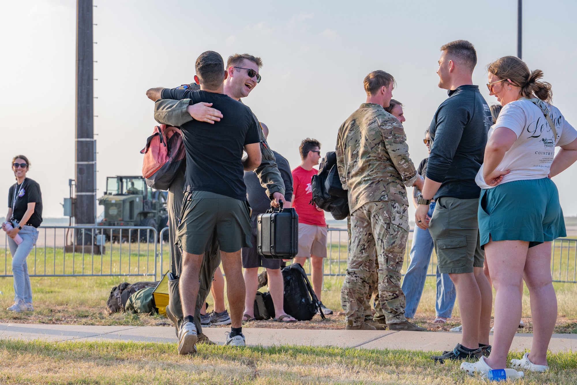 U.S. Airmen assigned to the 317th Airlift Wing embrace their loved ones after returning home from a deployment Dyess Air Force Base, Texas, May 18, 2026. The deployment demonstrated the wing's capacity to execute airlift and airdrop missions in austere environments while responding to contingency requirements for combatant commands worldwide. (U.S. Air Force photo by Airman 1st Class Caleb Schellenberg)