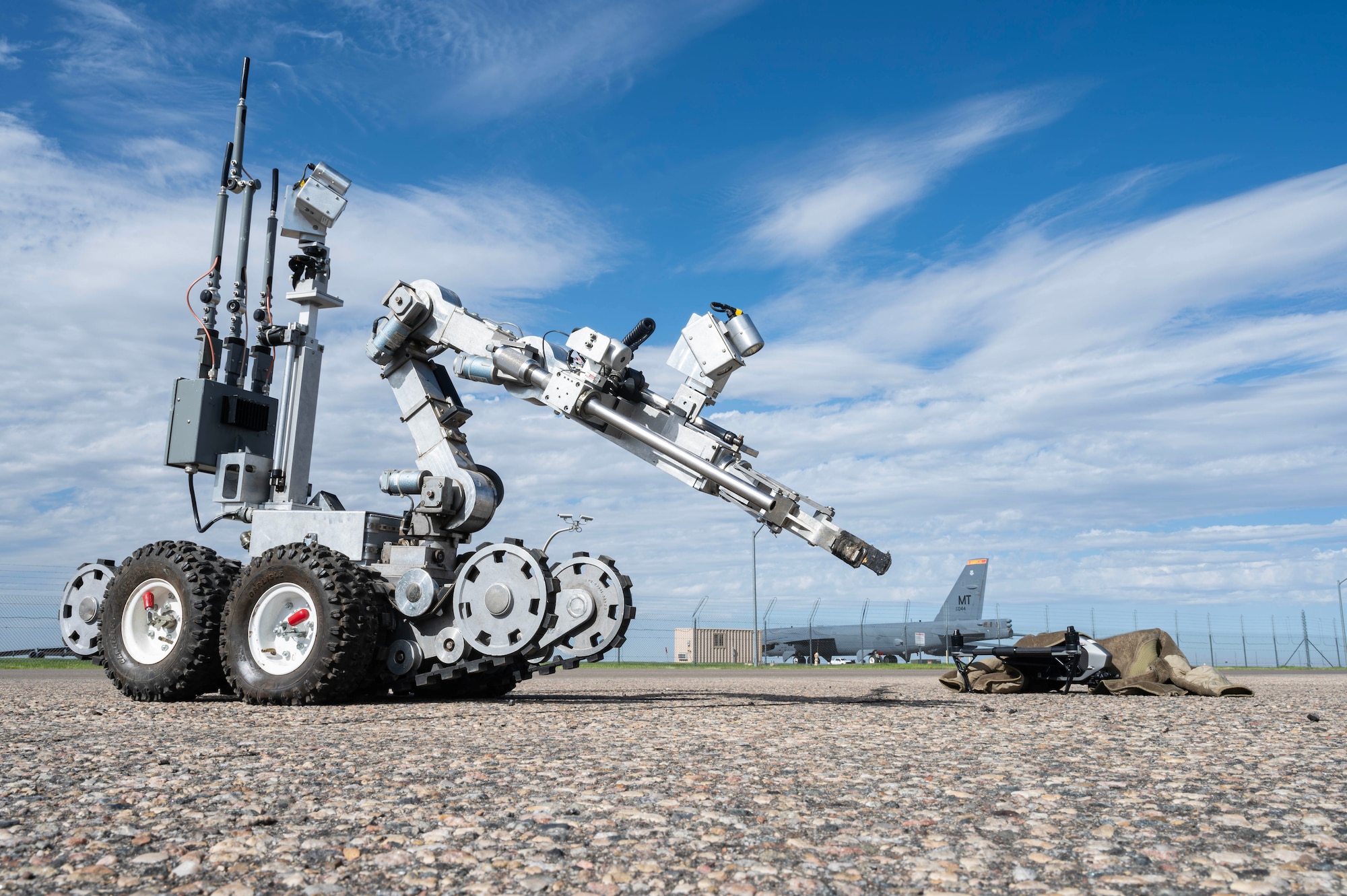 An explosive ordnance disposal robot examines a downed small unmanned aircraft system (sUAS) during Warbird Week at Minot Air Force Base, North Dakota, May 14, 2026. Warbird Week validated Team Minot’s ability to detect, defend against, and defeat sUAS threats. (U.S. Air Force photo by Senior Airman Kyle Wilson)