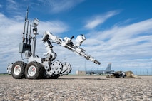 An explosive ordnance disposal robot examines a downed small unmanned aircraft system (sUAS) during Warbird Week at Minot Air Force Base, North Dakota, May 14, 2026. Warbird Week validated Team Minot’s ability to detect, defend against, and defeat sUAS threats. (U.S. Air Force photo by Senior Airman Kyle Wilson)