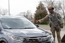 Airman 1st Class Se’kani Frett (right), 5th Security Forces Squadron (5 SFS) defender, scans Common Access Cards during Warbird Week at Minot Air Force Base, North Dakota, May 14, 2026. As a part of his duties, Frett determines whether or not an individual is authorized to gain access to the base. (U.S. Air Force photo by Airman Ben Selchow)