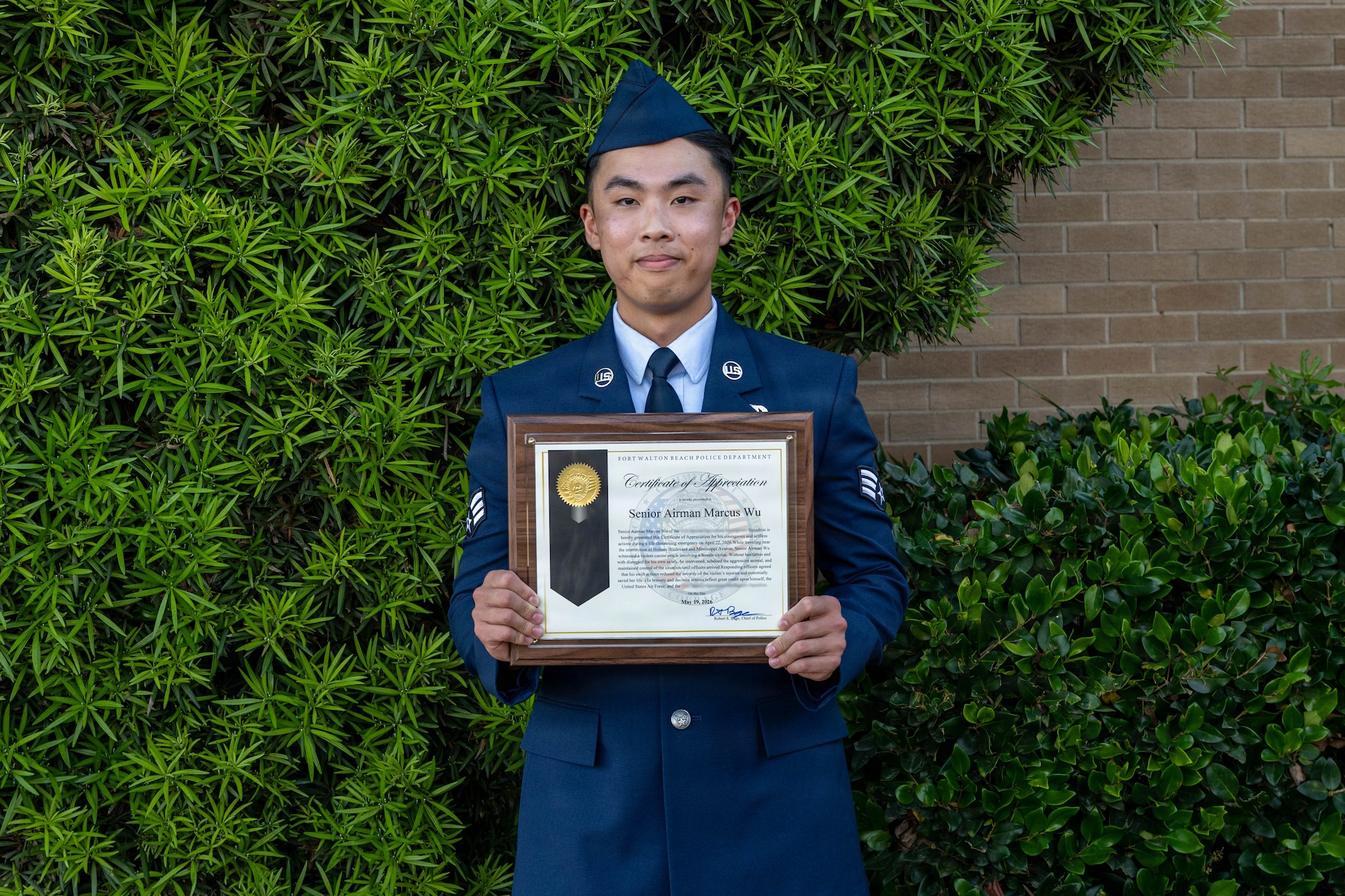 Airman poses for photo with award