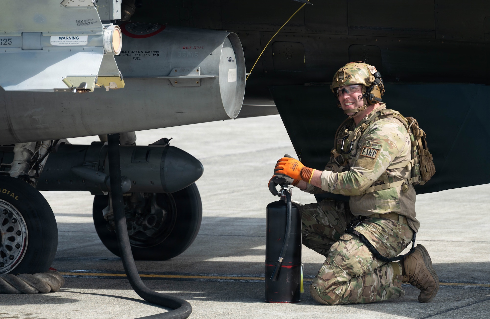U.S. Air Force Tech. Sgt. Devan Andersen, 176th Logistics Readiness Squadron noncommissioned officer in charge of fuels distribution, awaits the signal for refueling completion during a forward arming and refueling point operation at Joint Base Elmendorf-Richardson, Alaska, May 15, 2026.