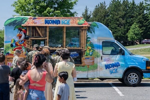 People standing on a line in front of a food truck.