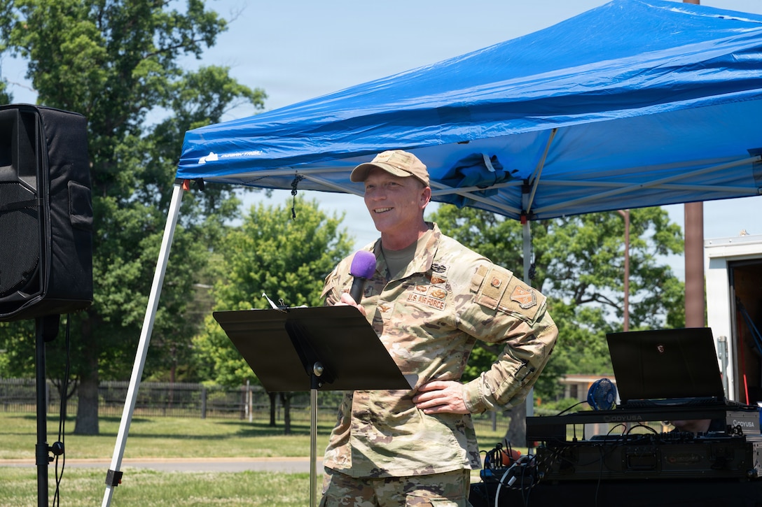 Man holding microphone in front of stand.