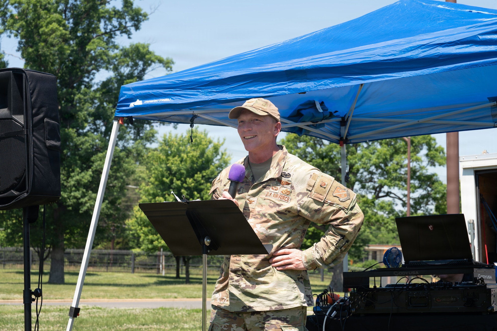 Man holding microphone in front of stand.